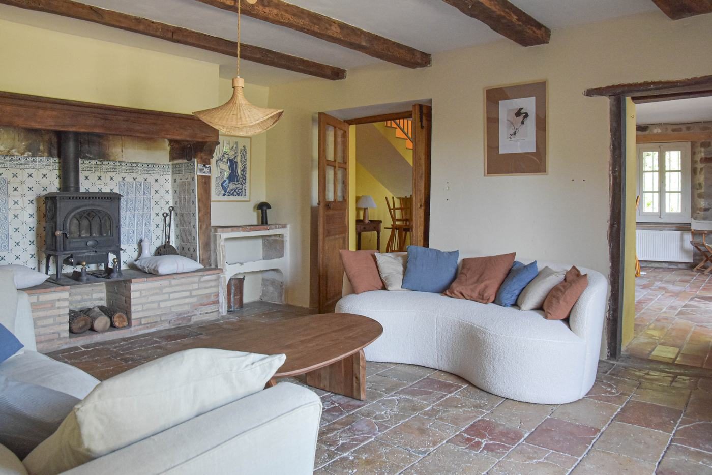 Le salon : poêle à bois, faïences bleues, canapés et table basse en bois
